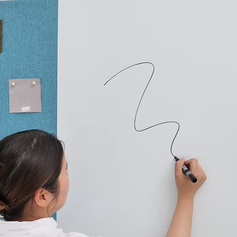 Valkoinen kirjoitusakustinen taulu toimiston kokoushuoneen kankaaseen, joka on kääritty magneettisella karkaistulla lasilla vaimentavalla tekstillä